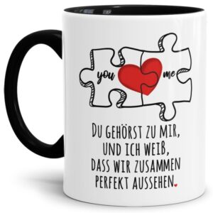 Liebevoll gestaltete Tasse in Schwarz mit Puzzleteil-Motiv und süßem Spruch - Du gehörst zu mir - für Verliebte